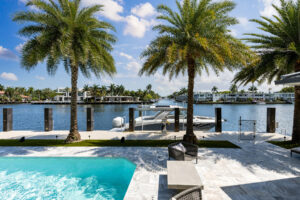 a stunning pool in the foreground overlooking a river with palm trees swaying